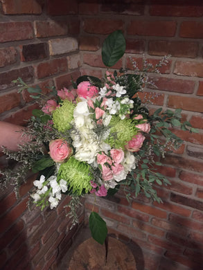 A gorgeous collection of sweet scented florals in a soft palette of white, pink and green skirted with premium foliages. Includes jumbo white hydrangea, pink roses, pink spray roses, white stocks, green spider mums, lavender limonium and pink statice. Hand tied and ready for your recipient to drop into her vase! Sure to take her breath away!