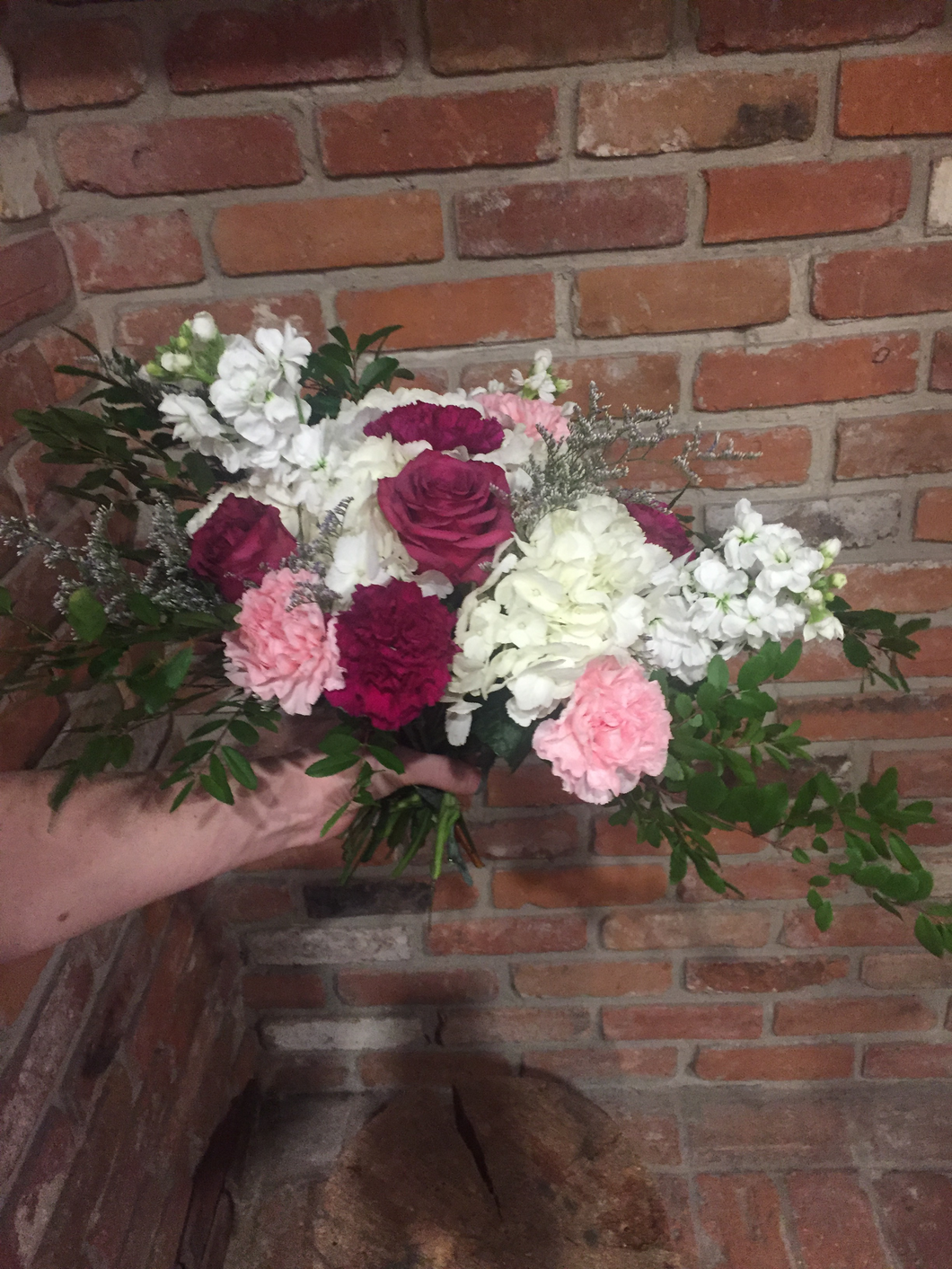 A beautiful garden style hand tied bouquet including a jumbo white hydgrangea, fragrant white stocks, blueberry roses and plum and light pink carnations. A touch of whispy lavender limonium and an assortment of foliages add loads of texture! Arranged and ready for your recipient to drop in their vase